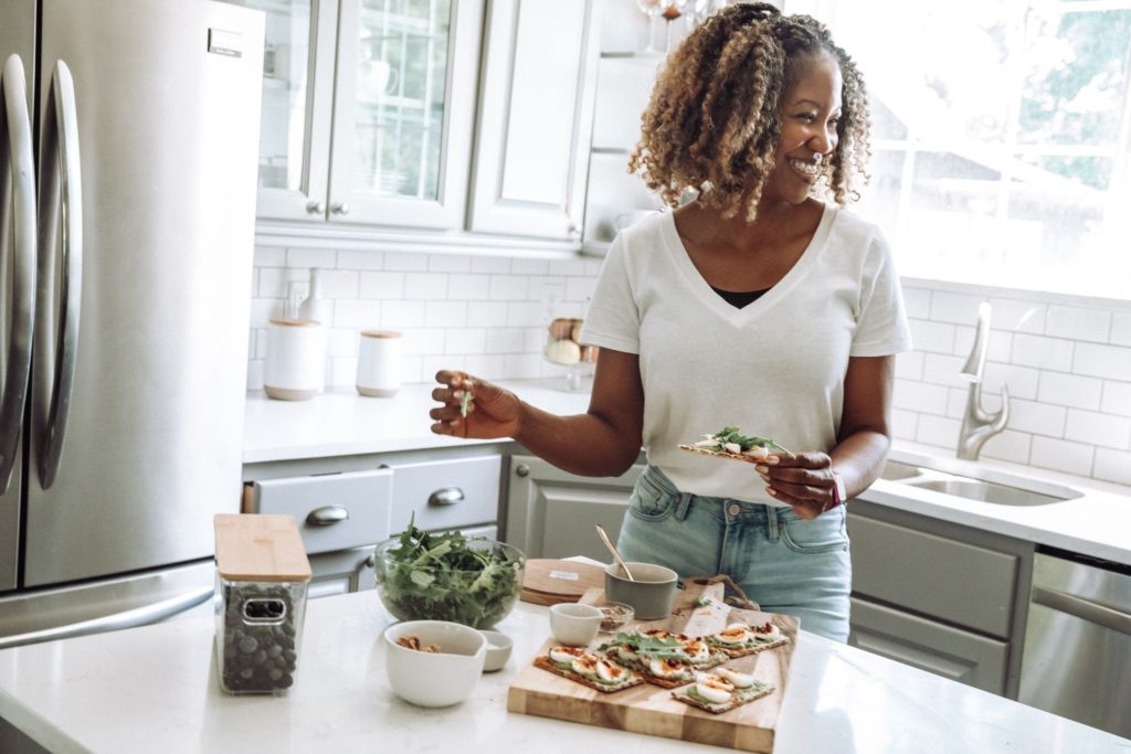 Photo of a girl making hors d'oeuvres in a sunny kitchen